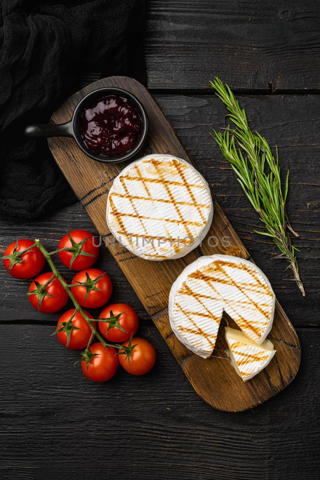 Grilled goat cheese, on black wooden table background, top view flat lay