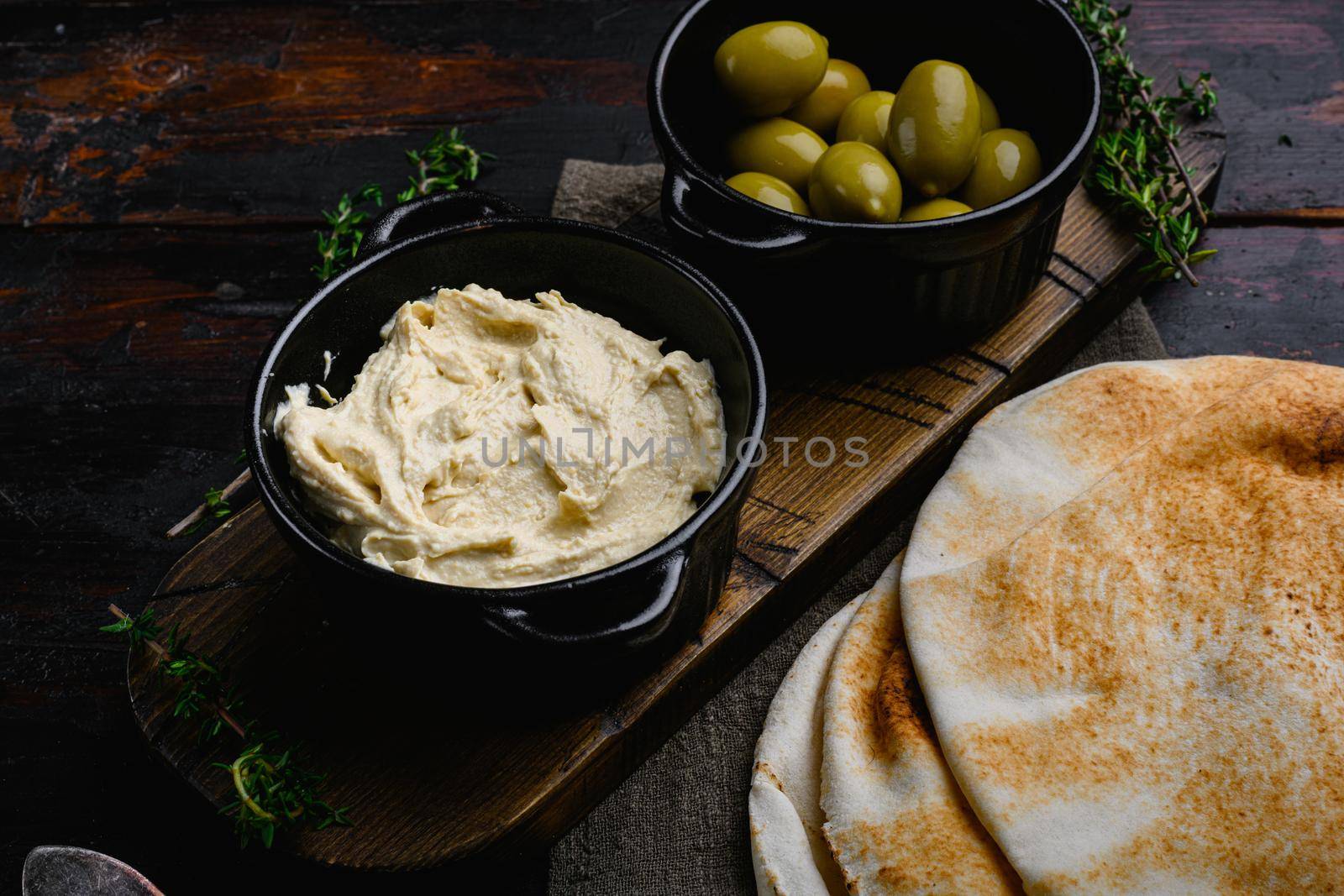 Healthy Homemade Creamy Hummus set, on old dark wooden table background by Ilianesolenyi
