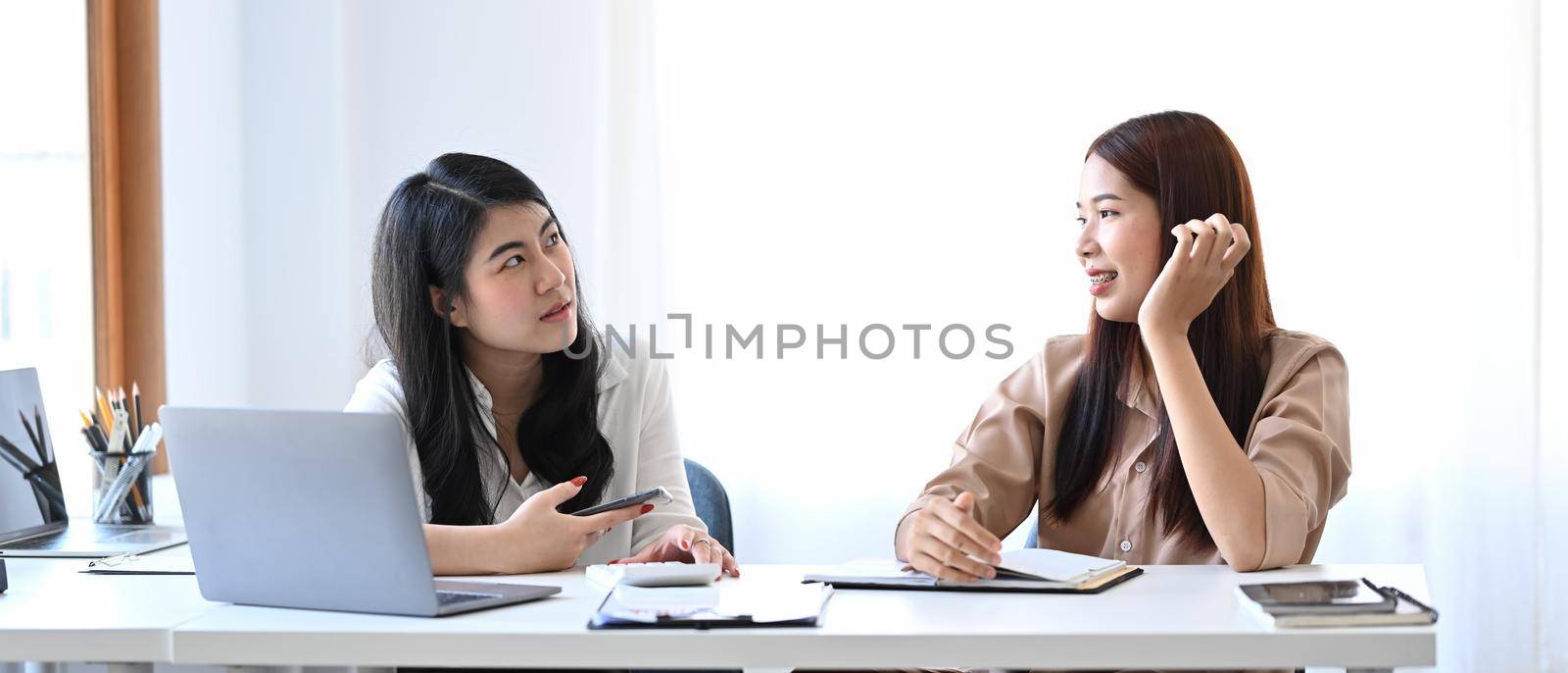Asian businesswoman sharing ideas or startup business plan other colleague. by prathanchorruangsak