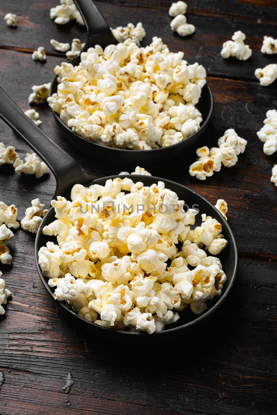 Prepared salted popcorn, on old dark wooden table background