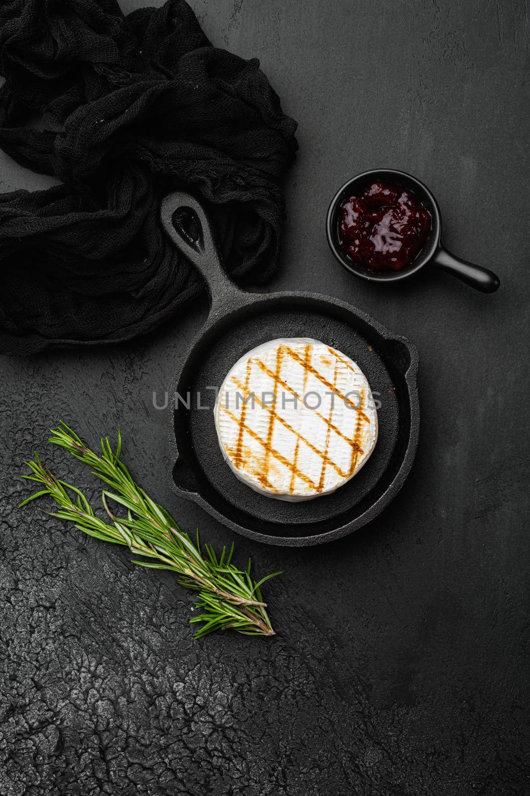 Baked Camembert cheese, on black dark stone table background, top view flat lay, with copy space for text