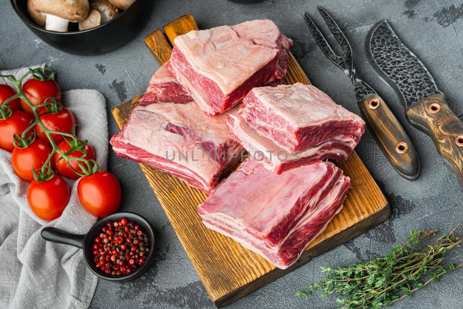 Raw Black Angus Marbled Beef Ribs, with ingredients , on gray stone background by Ilianesolenyi