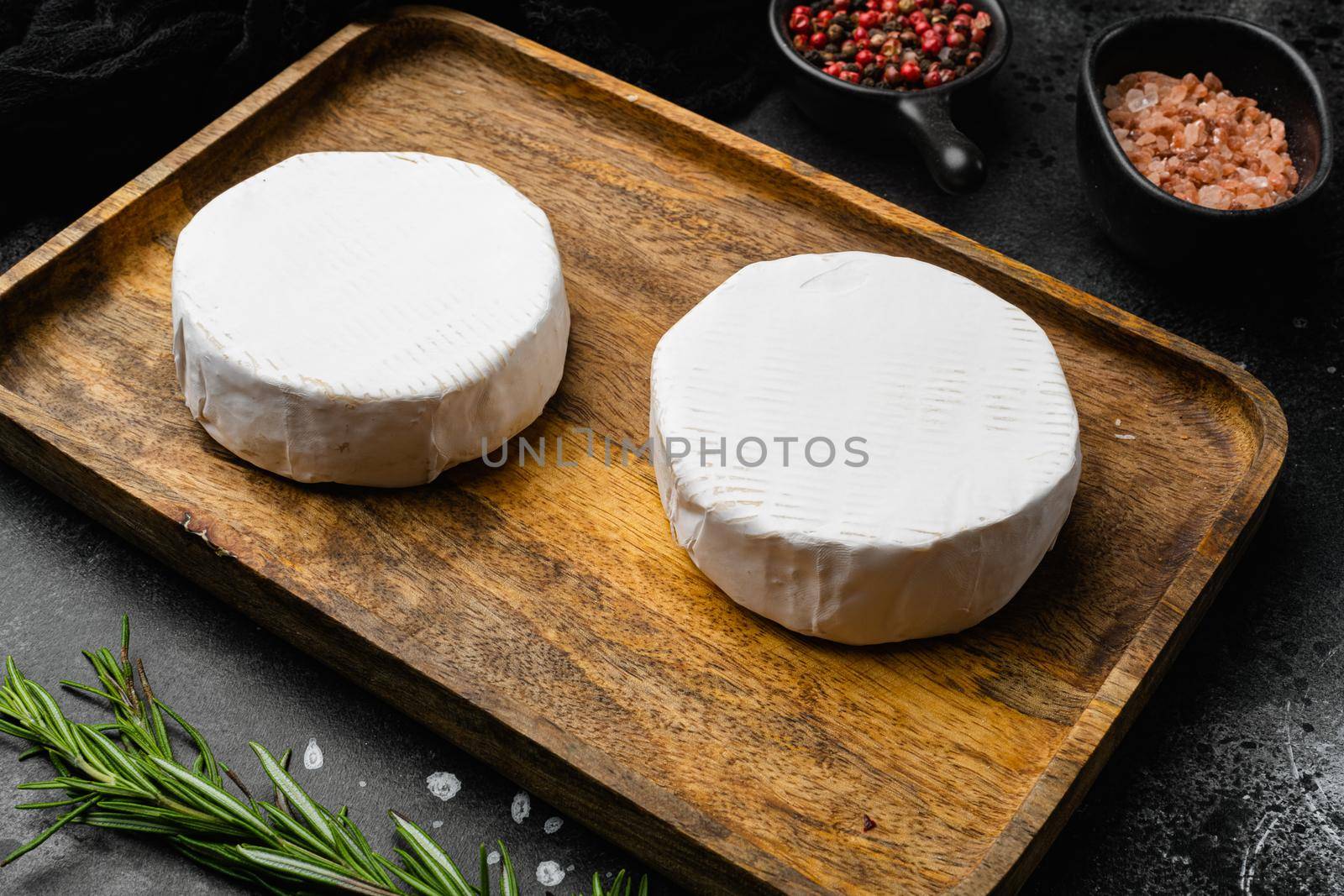 White cheese brie or camembert. Gourmet appetizer on black dark stone table background by Ilianesolenyi