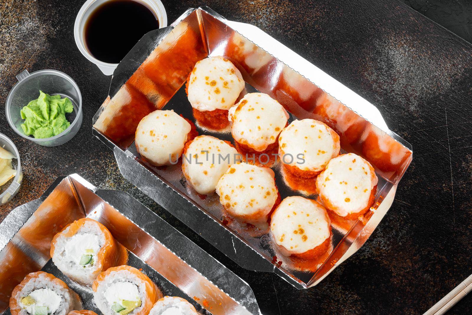 Set of sushi rolls in delivery food box, on old dark rustic background by Ilianesolenyi