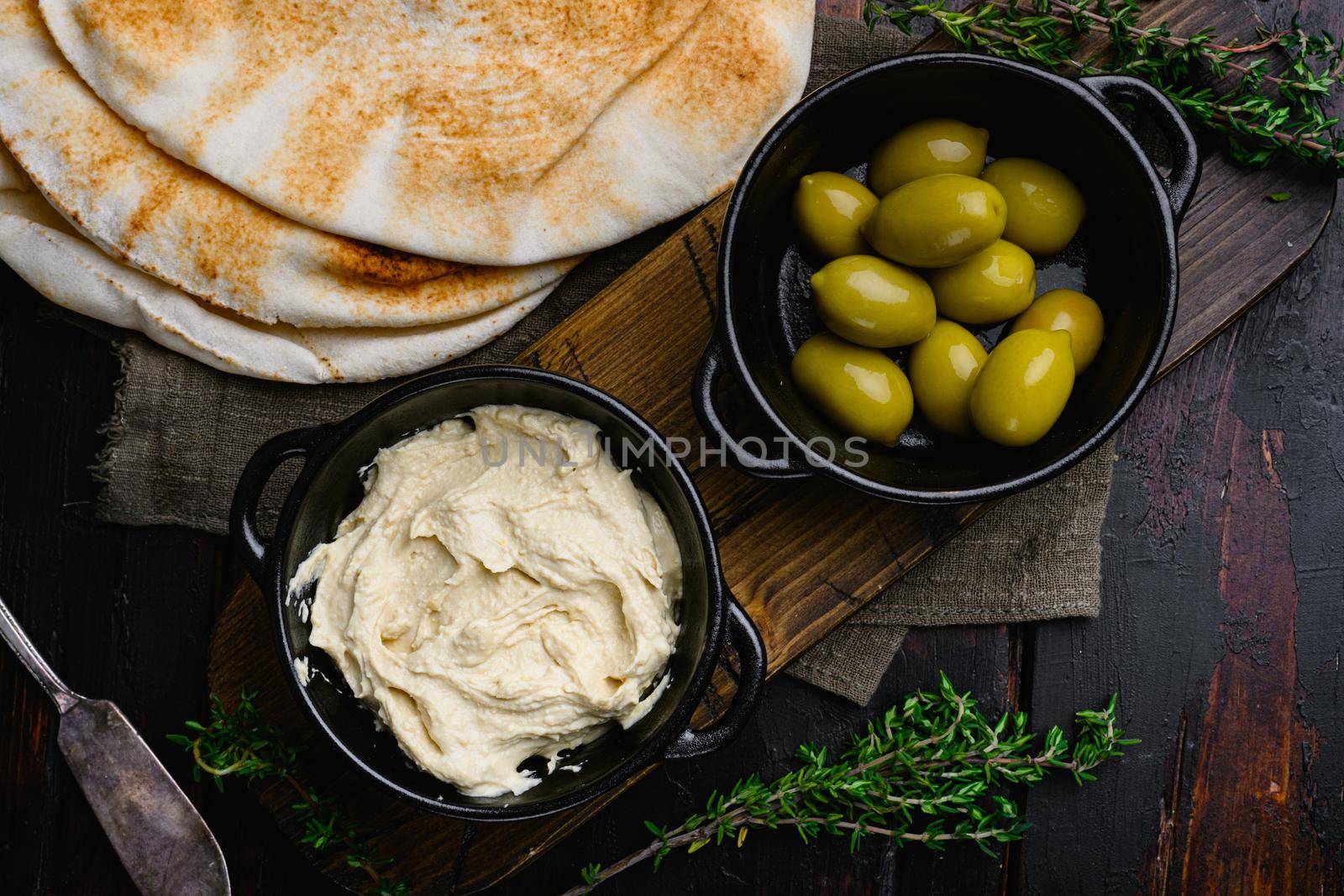 Hummus traditional Jewish creamy lunch set, on old dark wooden table background, top view flat lay by Ilianesolenyi