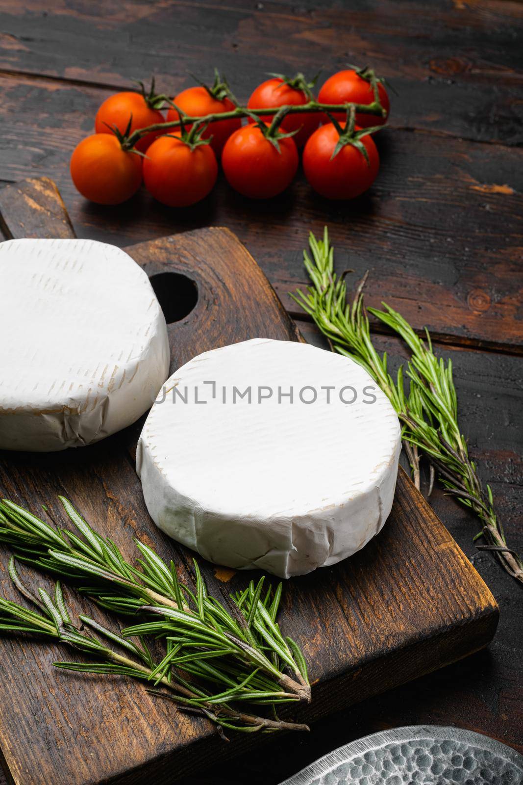 Soft creamy brie cheese, on old dark wooden table background