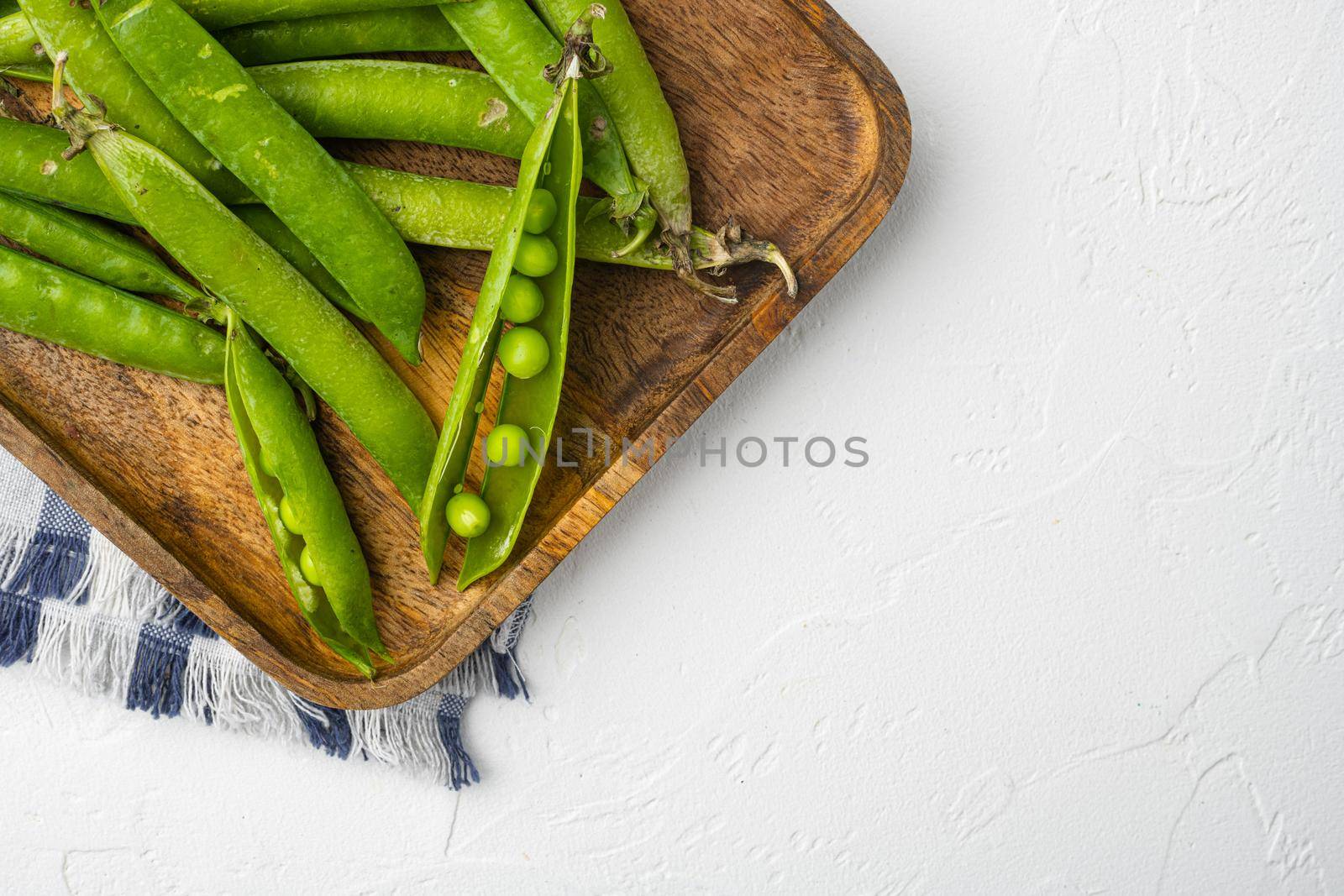 Fresh picked green pea on white stone table background, top view flat lay, with copy space for text by Ilianesolenyi