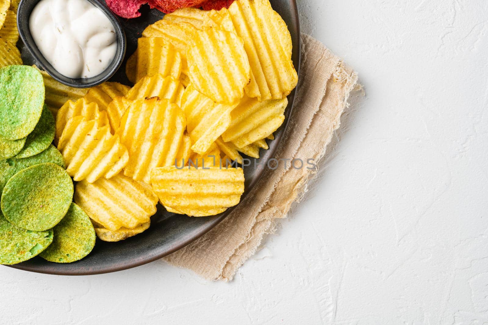 Crispy potato chips, on white stone table background, top view flat lay, with copy space for text