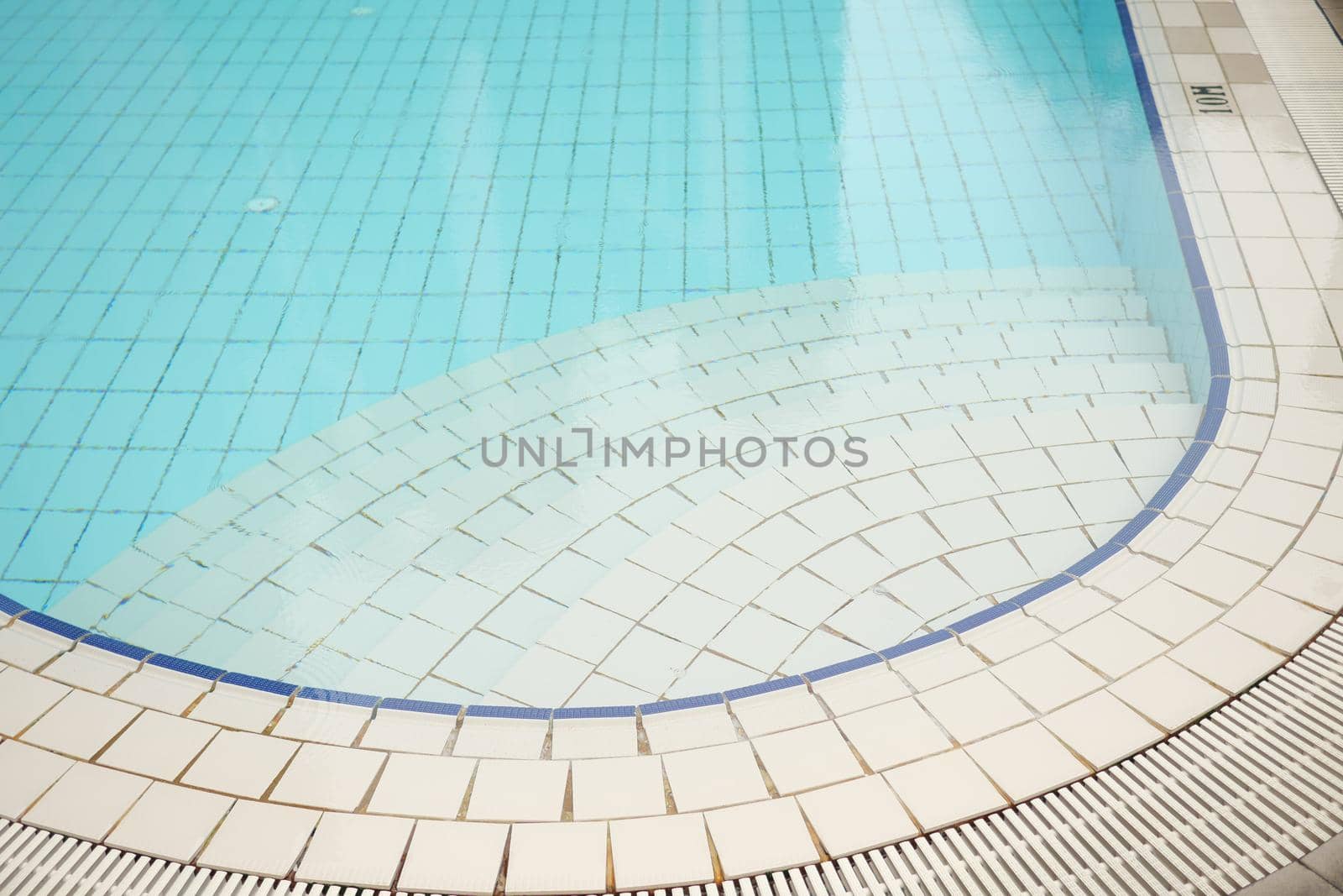 an empty swimming pool with poll stair.