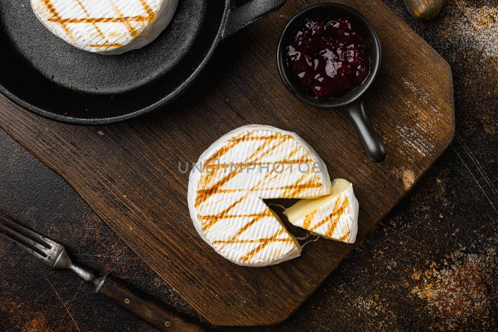 Grilled camembert or brie cheese on old dark rustic table background, top view flat lay by Ilianesolenyi