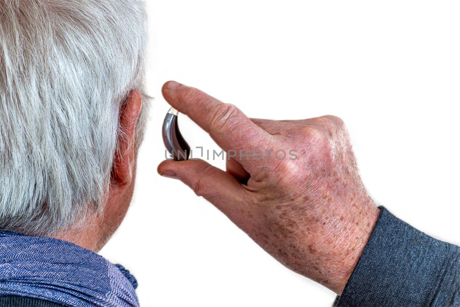 American plan on the installation of a hearing aid of a senior with white cheuveux rear view.