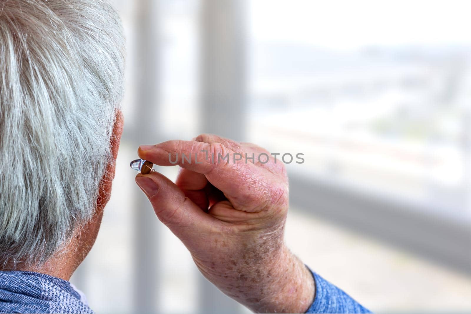Hearing aid in a senior man by JPC-PROD