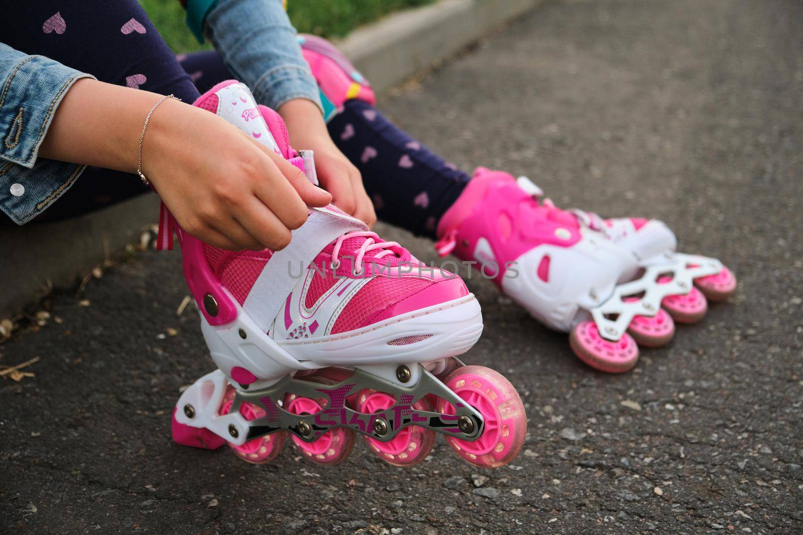 little girl learning to roller skate outdoor. Child enjoying roller skating ride outdoors. Close-up Of Legs Wearing Roller Skating Shoe, Outdoors