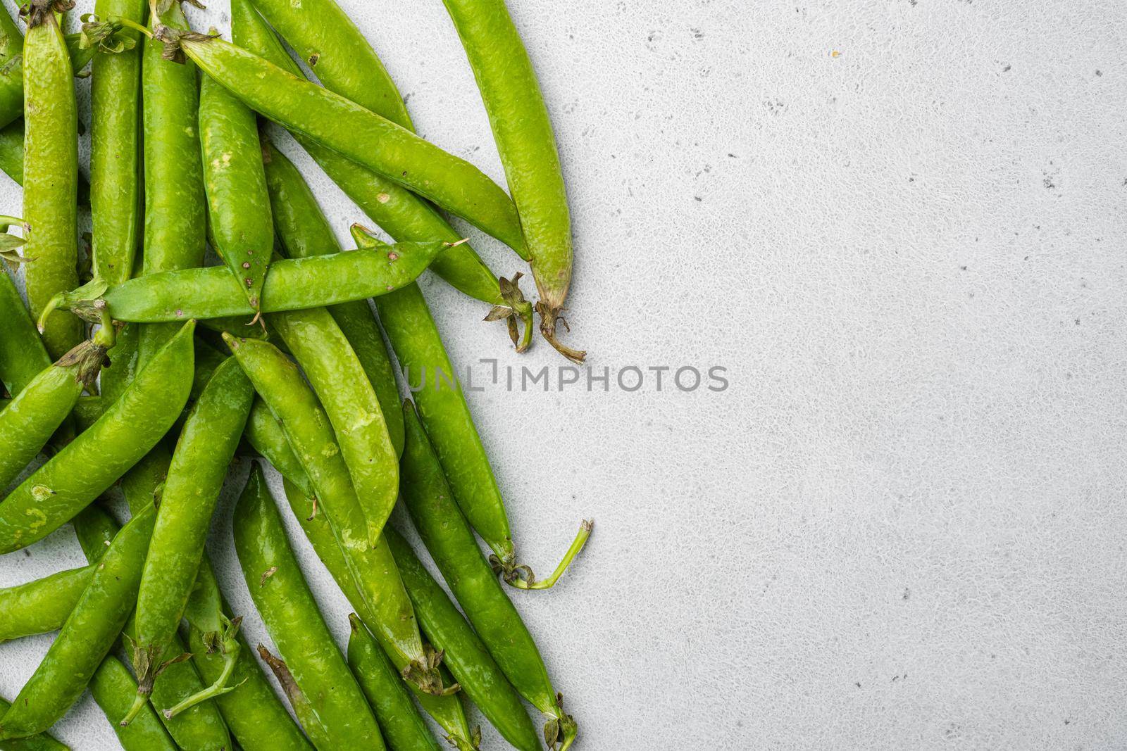 Green peas Freshly harvested on gray stone table background, top view flat lay, with copy space for text by Ilianesolenyi