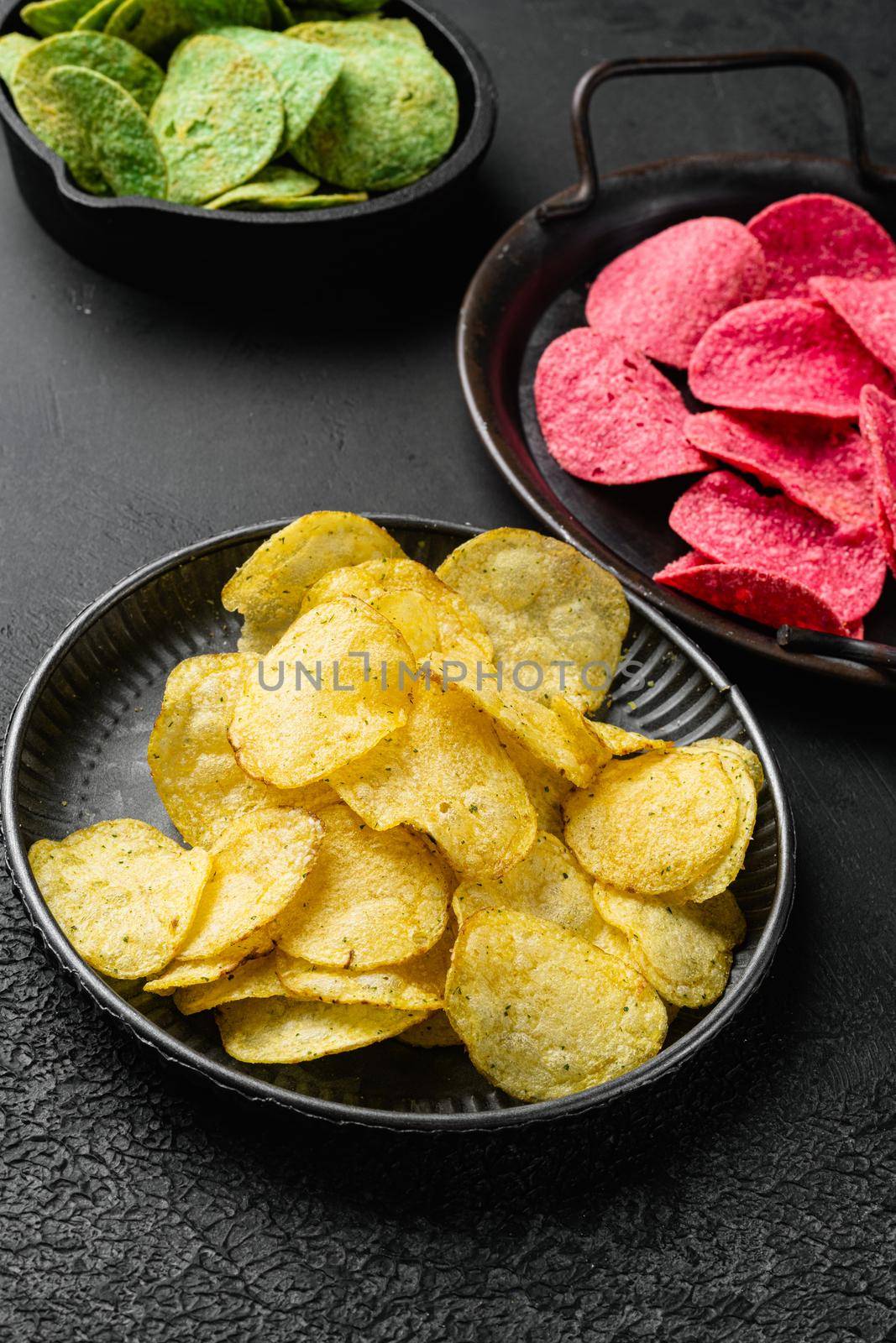 Classic Potato Chips on black dark stone table background by Ilianesolenyi