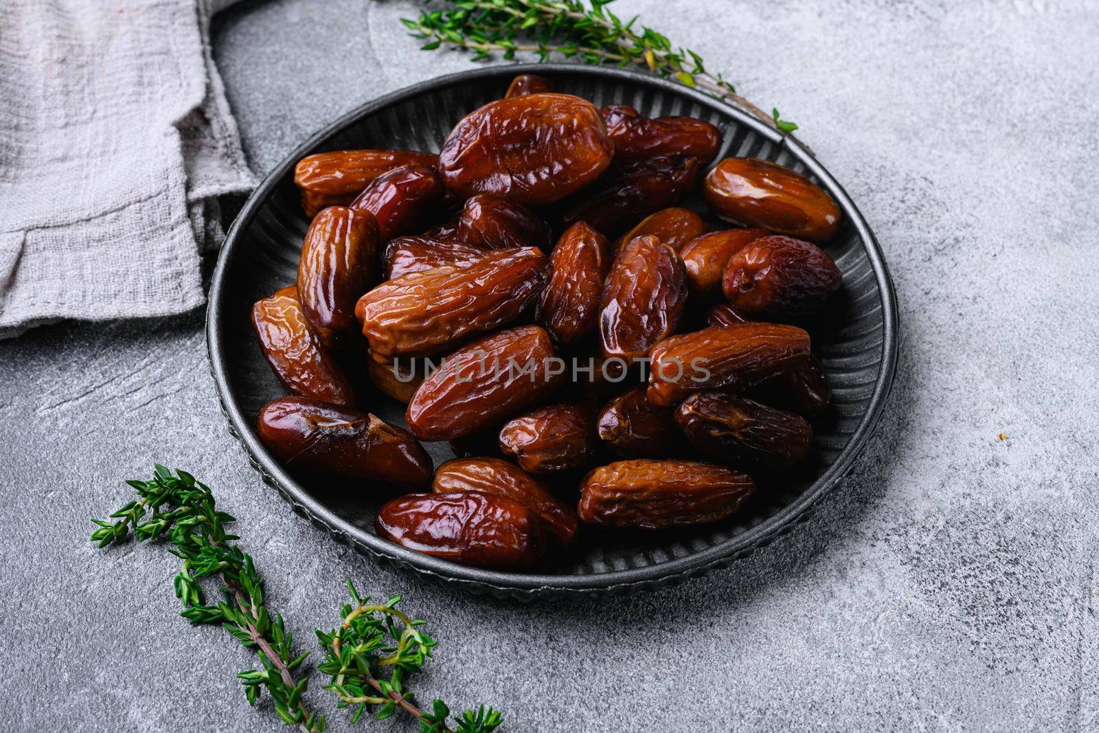 Ramadan dates is traditional food for iftar in islamic world set, on gray stone table background by Ilianesolenyi
