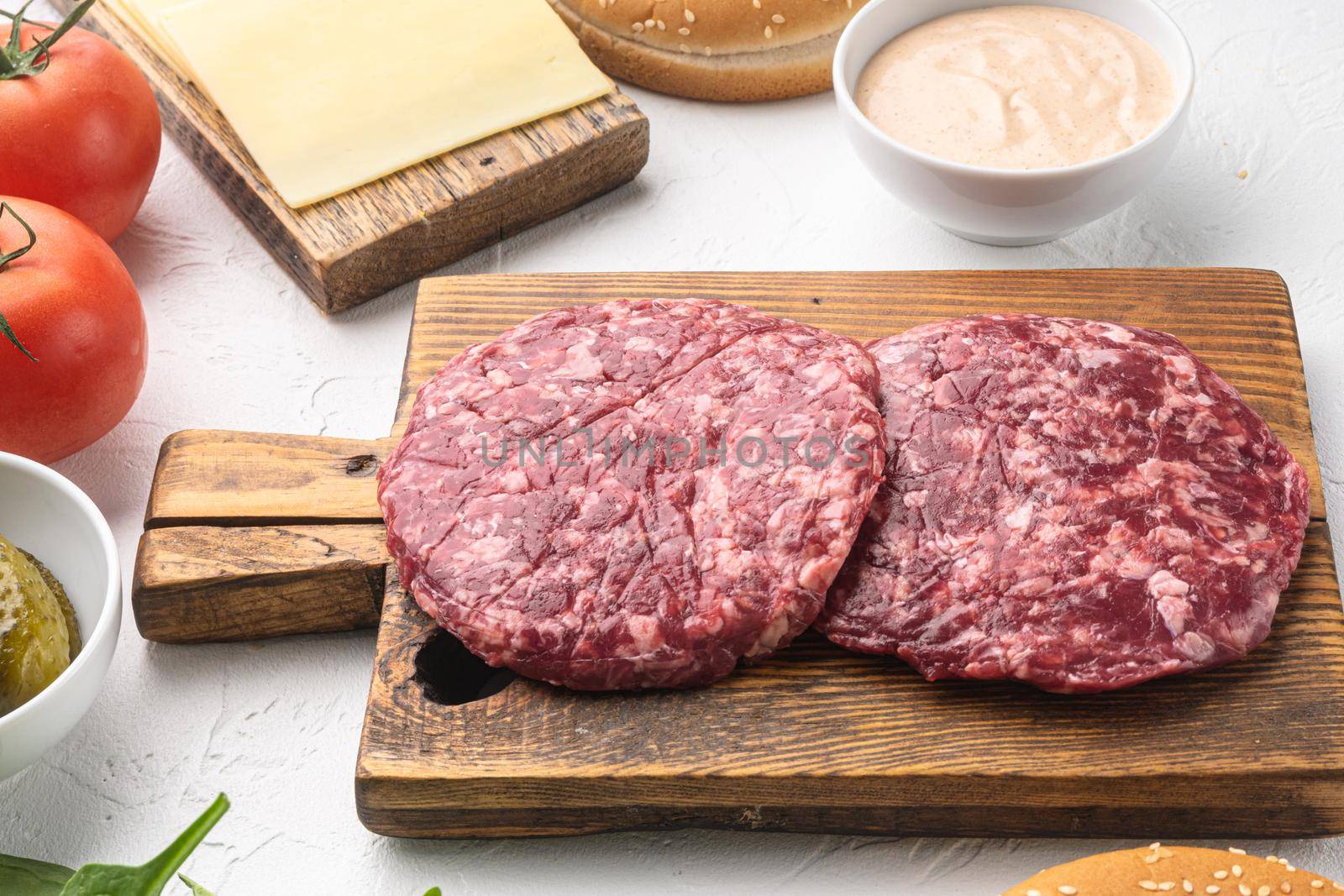 Raw Minced Steak Burgers from Beef Meat, on white stone background by Ilianesolenyi