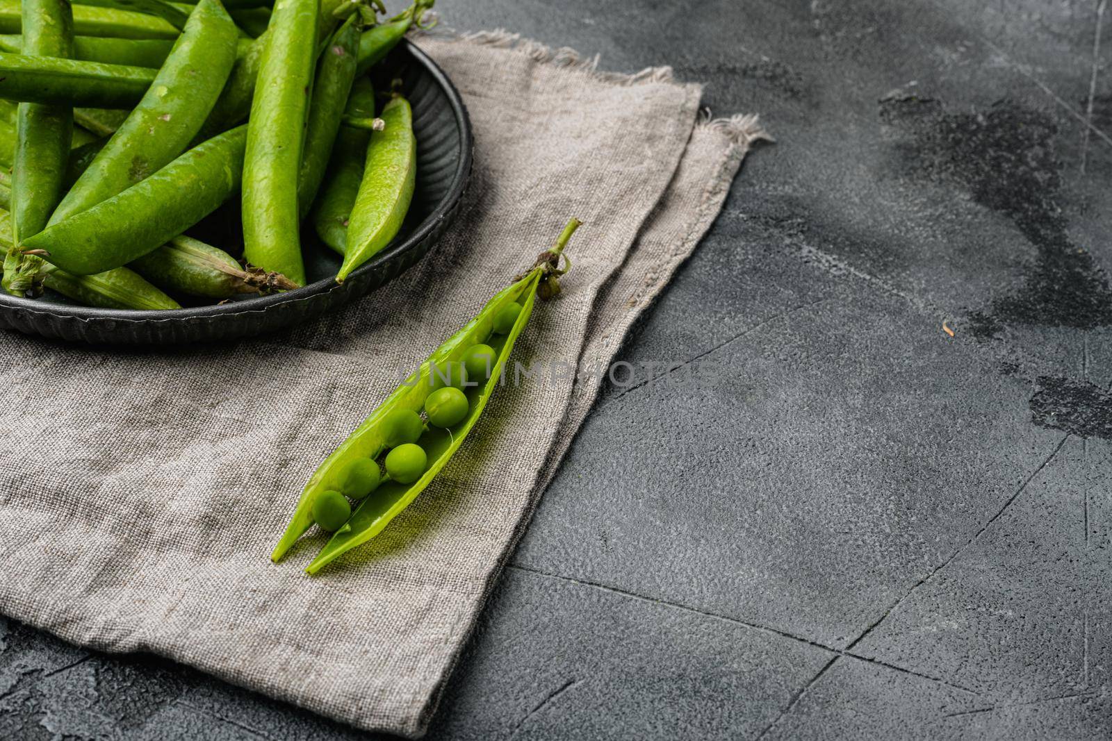 Fresh picked green pea, on gray stone table background, with copy space for text