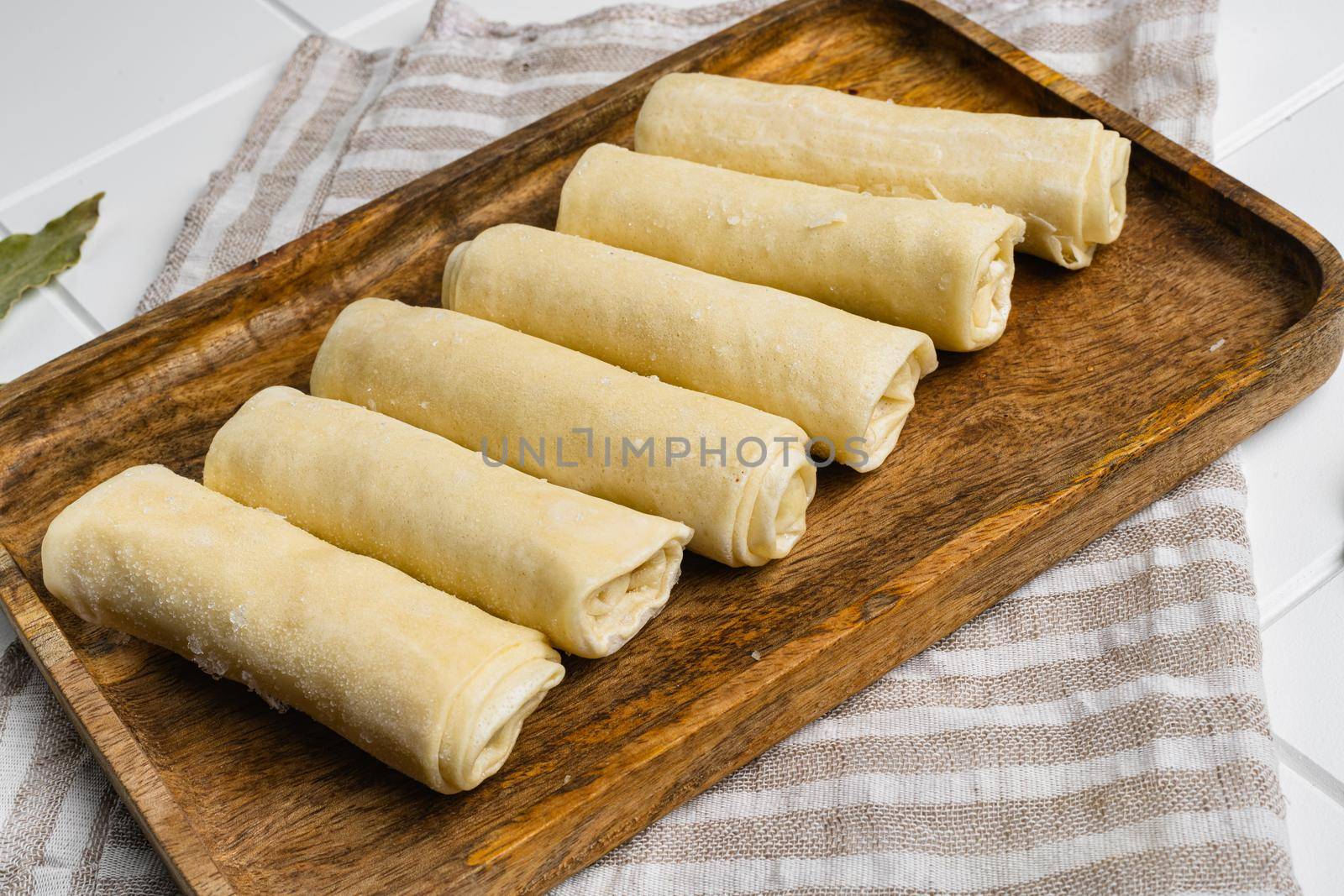 Frozen pancakes with meat, on white ceramic squared tile table background