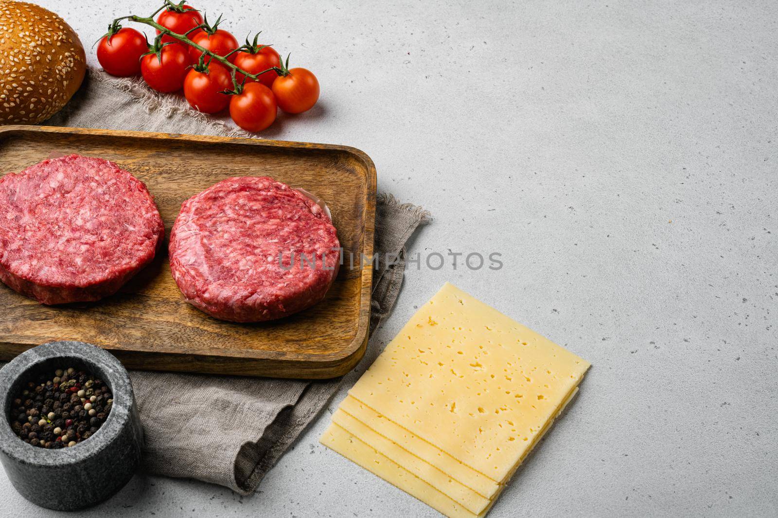Home Handmade Raw Minced Beef steak burgers, on gray stone table background, with copy space for text