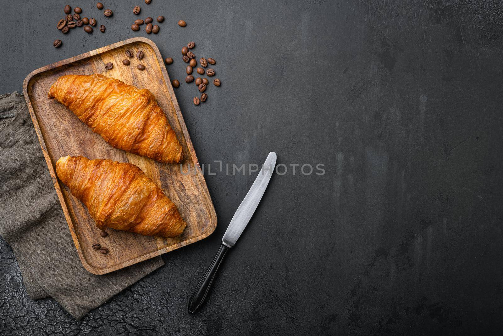 Fresh croissants on table set, on black dark stone table background, top view flat lay, with copy space for text by Ilianesolenyi