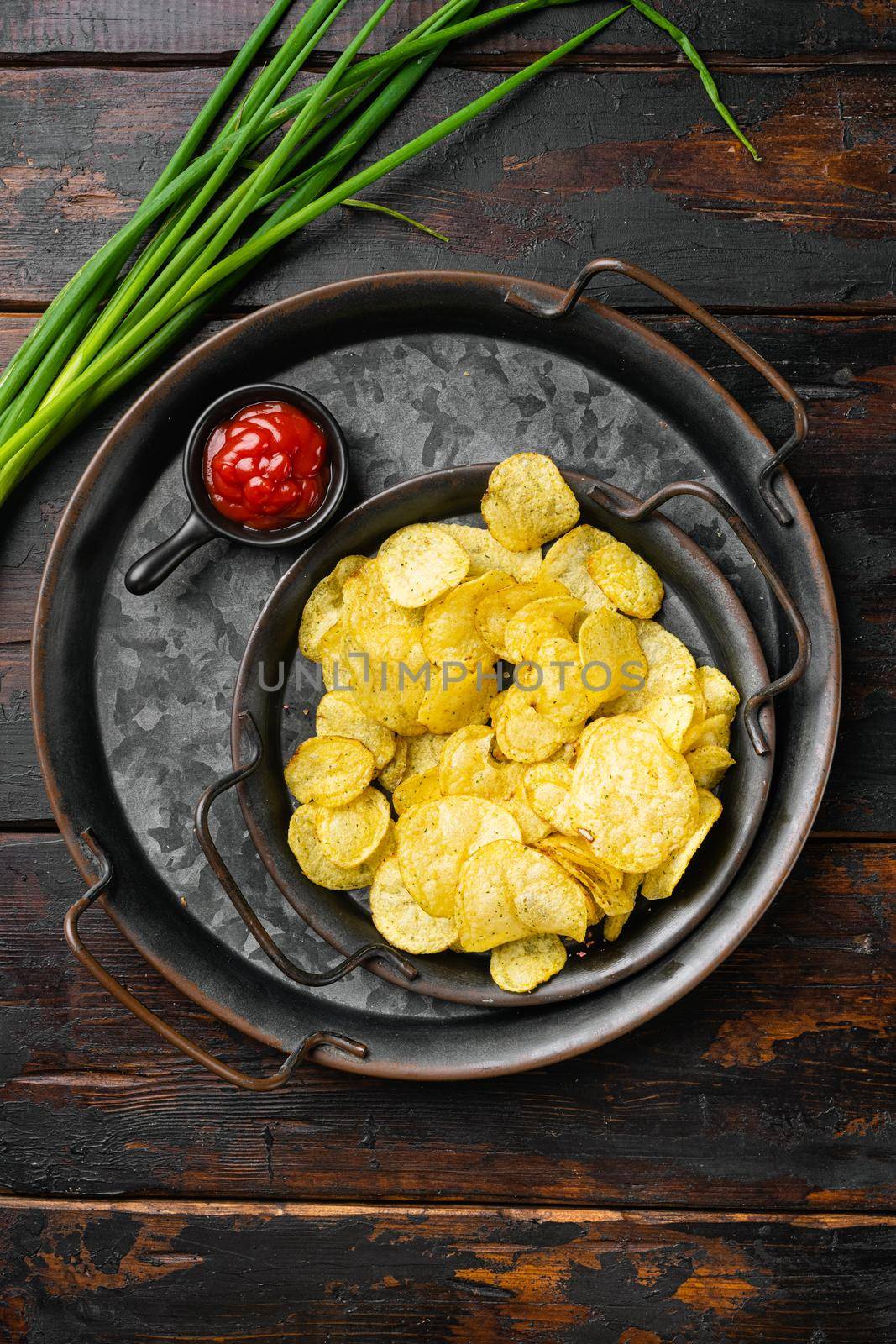 Salt Vinegar Flavored Potato Chips, on old dark wooden table background, top view flat lay