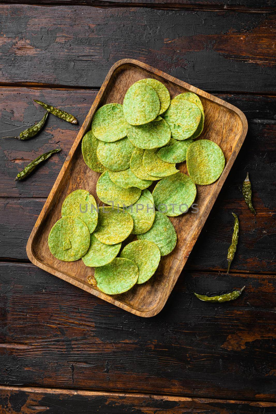 Green Chile Limon Flavored Potato Chips on old dark wooden table background, top view flat lay by Ilianesolenyi