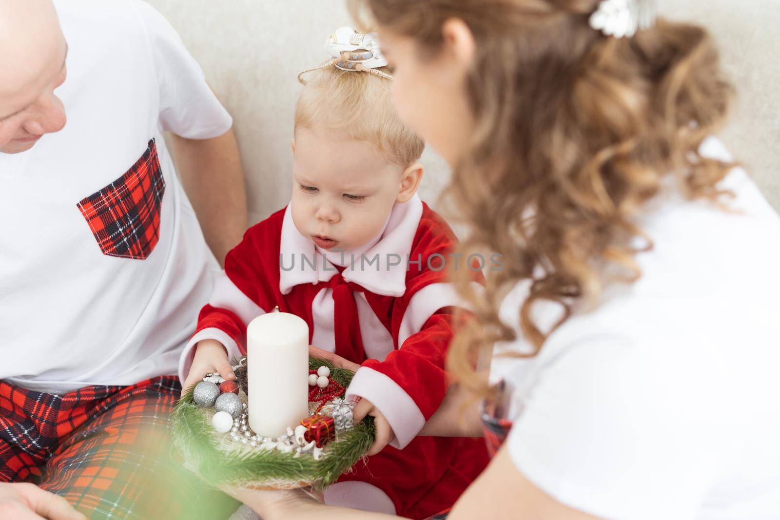 Baby child with hearing aid and cochlear implant having fun with parents in christmas room. Deaf , diversity and health concept by Satura86