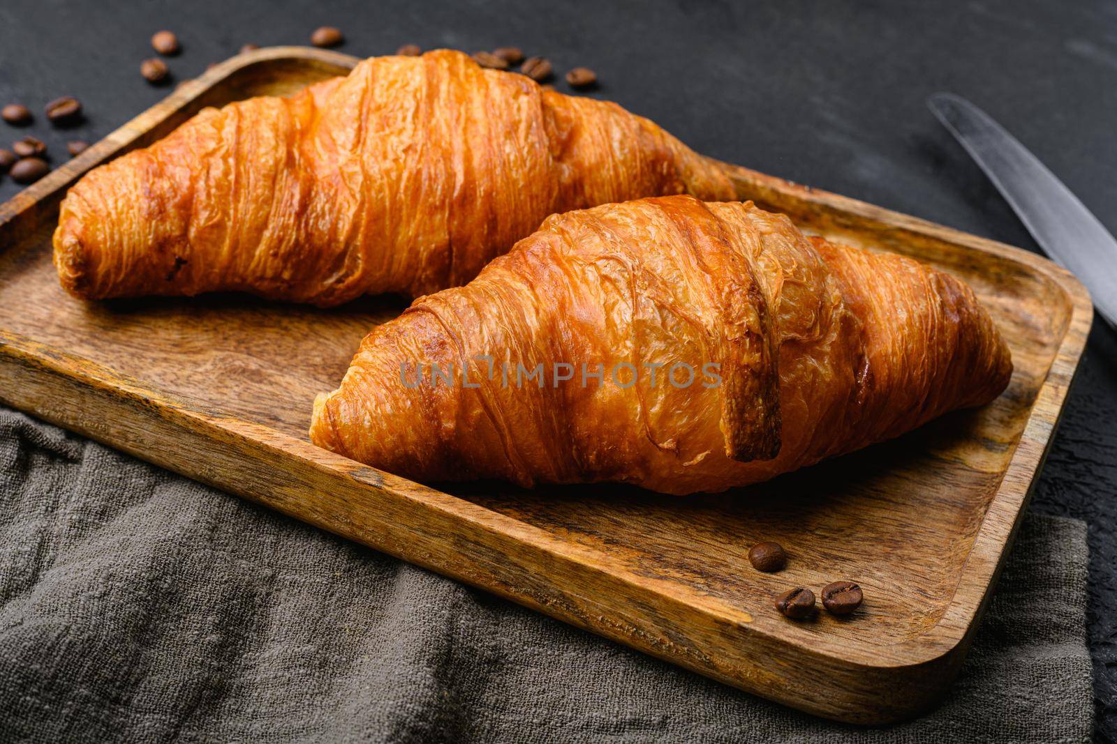 Warm butter creamy baked croissants set, on black dark stone table background by Ilianesolenyi