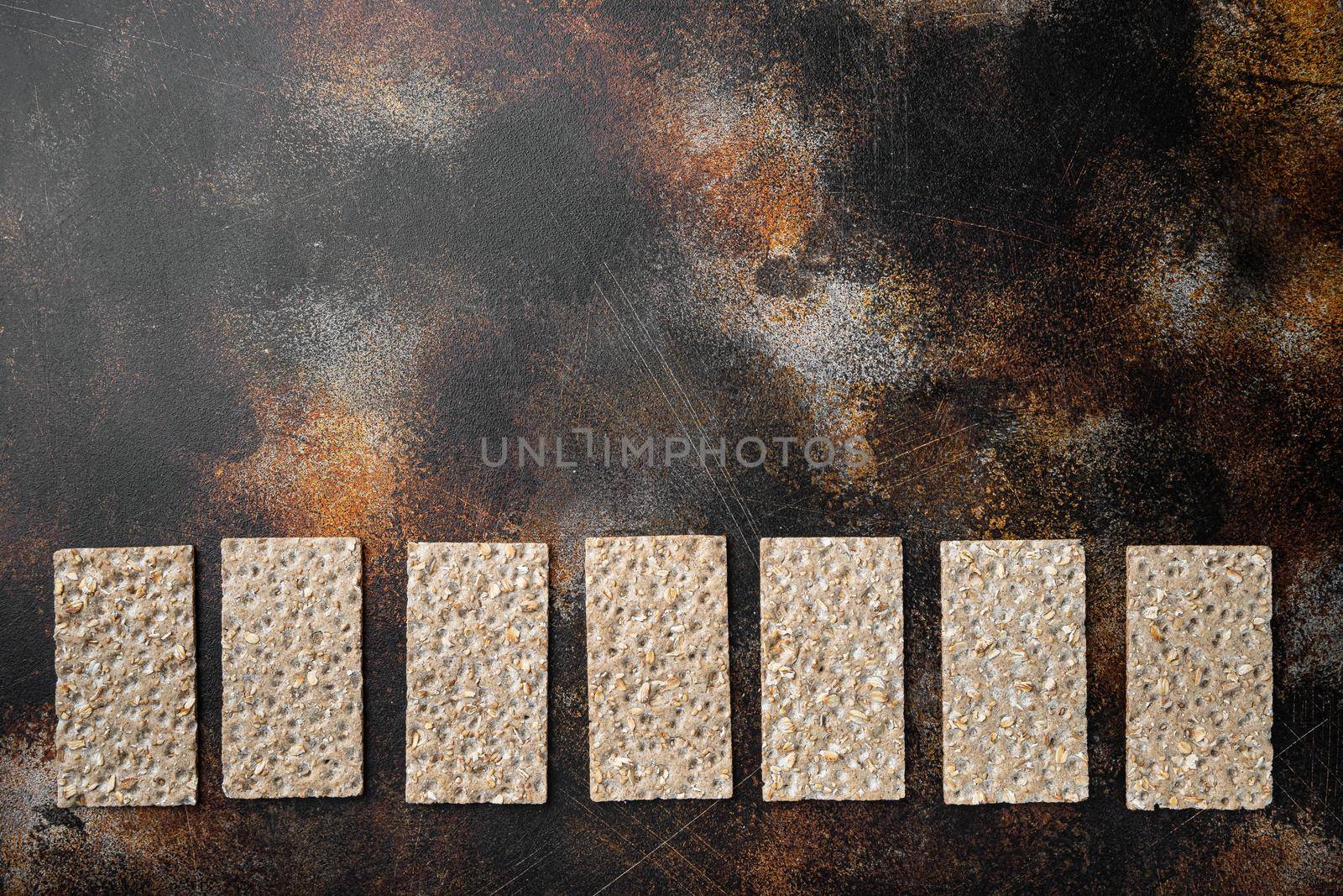 Thin rye crispy cracker set, on old dark rustic table background, top view flat lay, with copy space for text