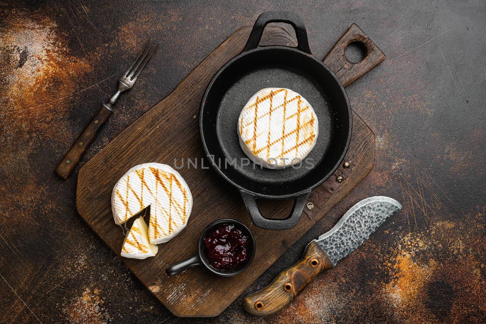 Grilled goat cheese on old dark rustic table background, top view flat lay by Ilianesolenyi