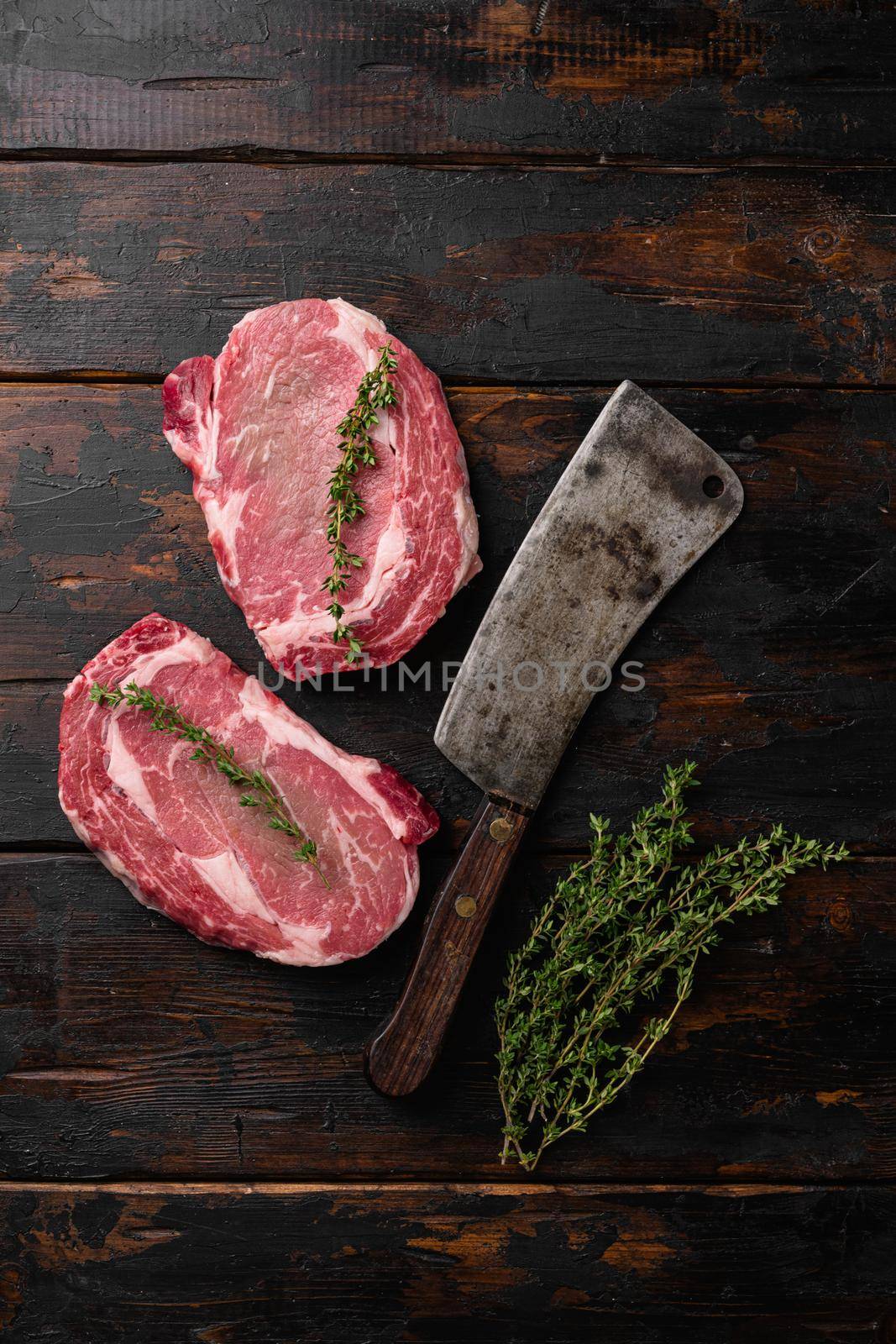 Perfect raw rib eye beef steak, on old dark wooden table background, top view flat lay by Ilianesolenyi