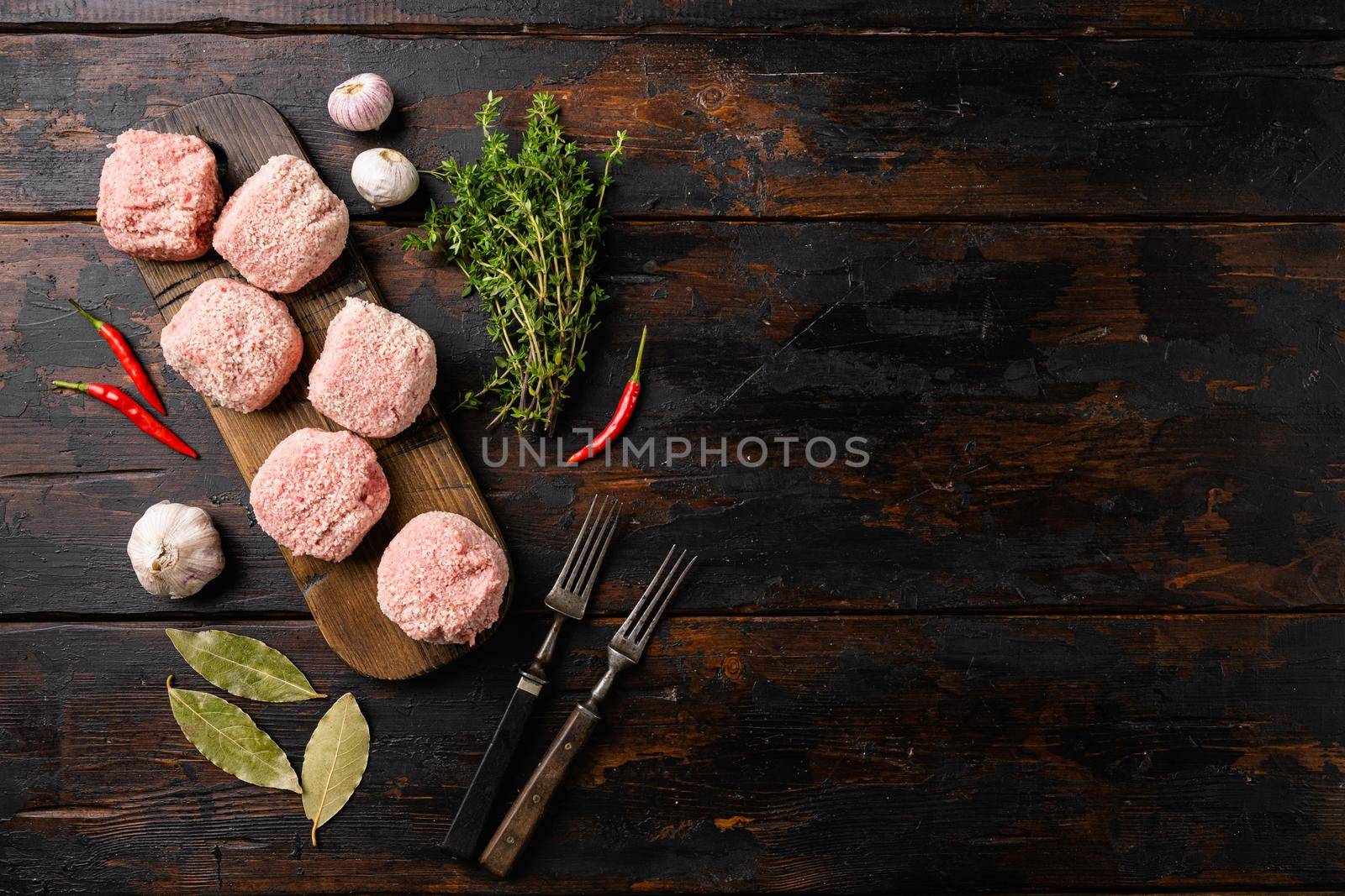 Raw ground beef meat steak cutlets set, on old dark wooden table background, top view flat lay, with copy space for text