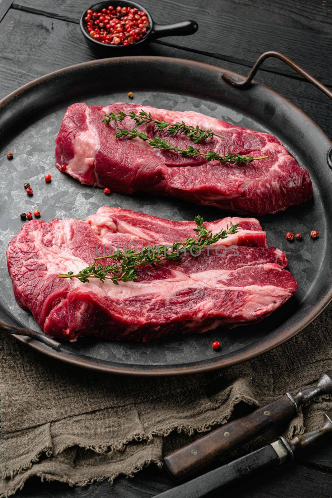 Chuck Eye Roll uncooked steak, on black wooden table background by Ilianesolenyi