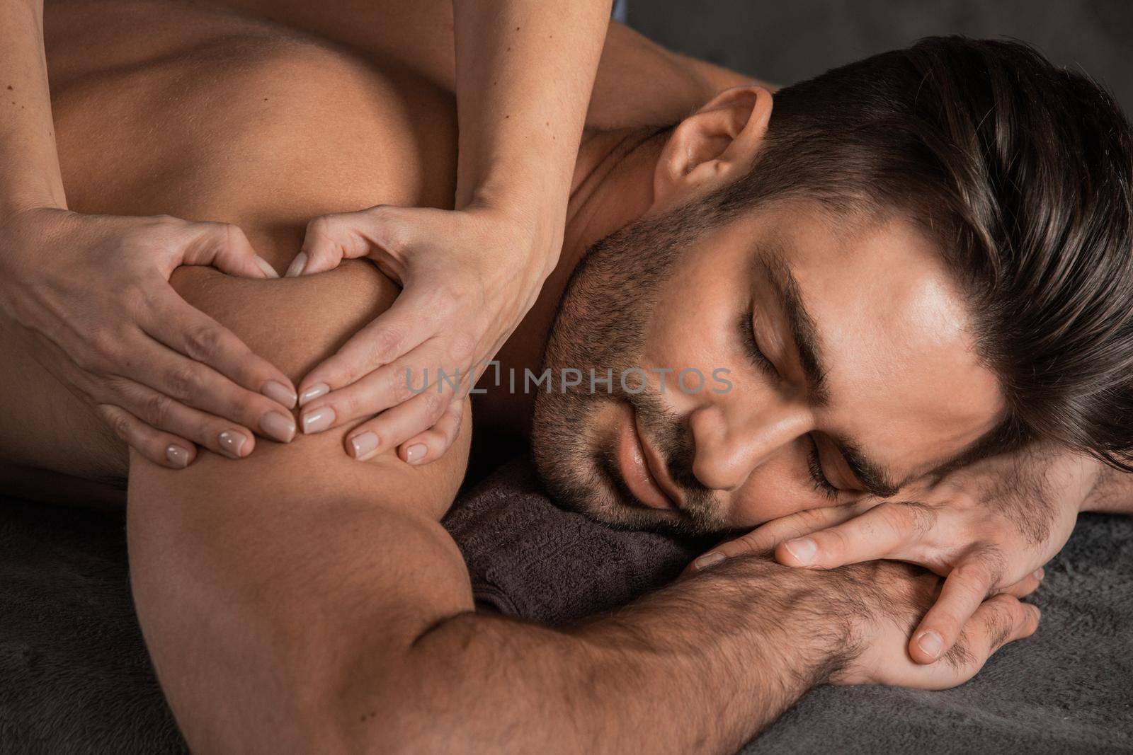 Man getting back massage at spa by ALotOfPeople