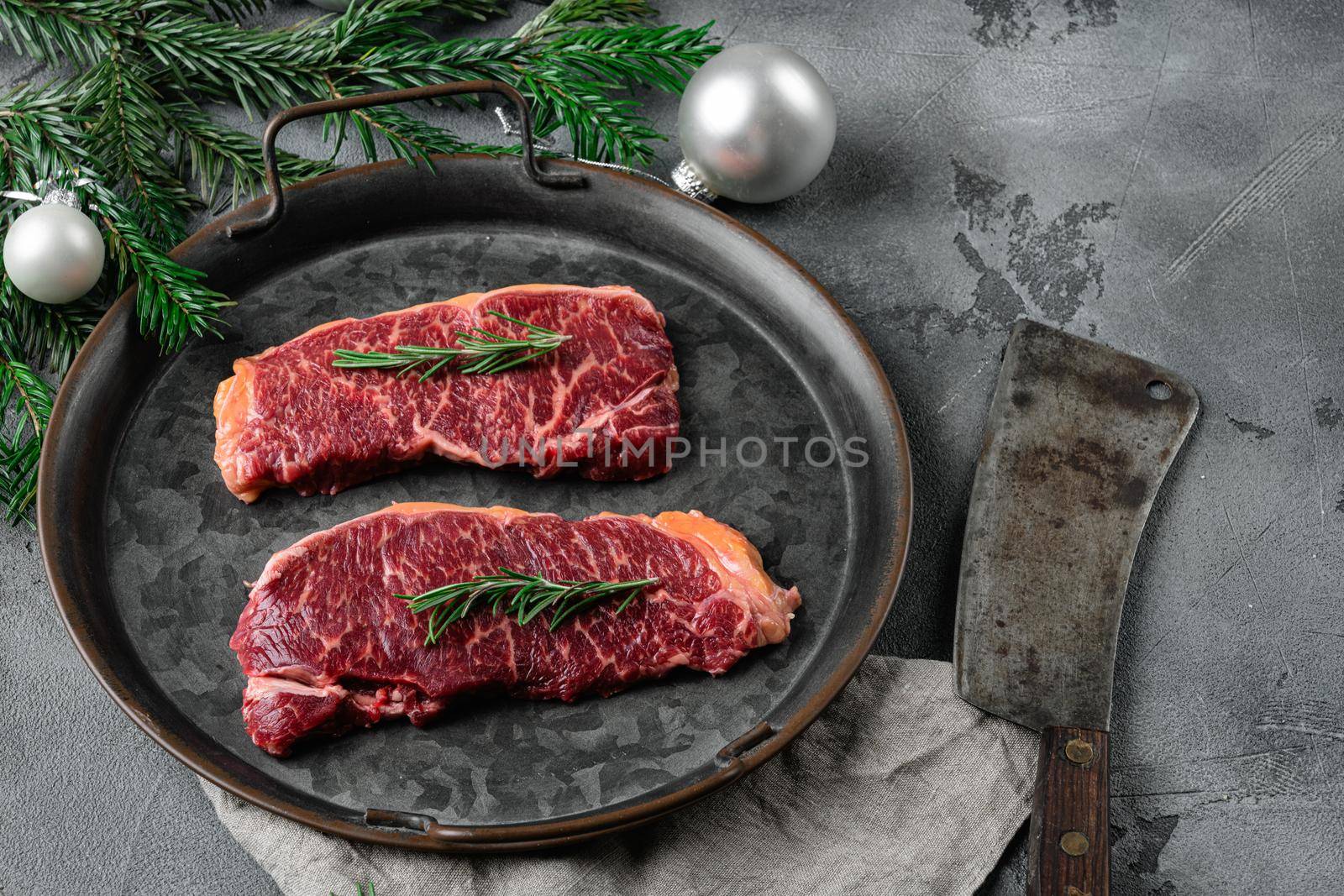 Christmas style New York beef steak cut , on gray stone table background, with copy space for text by Ilianesolenyi