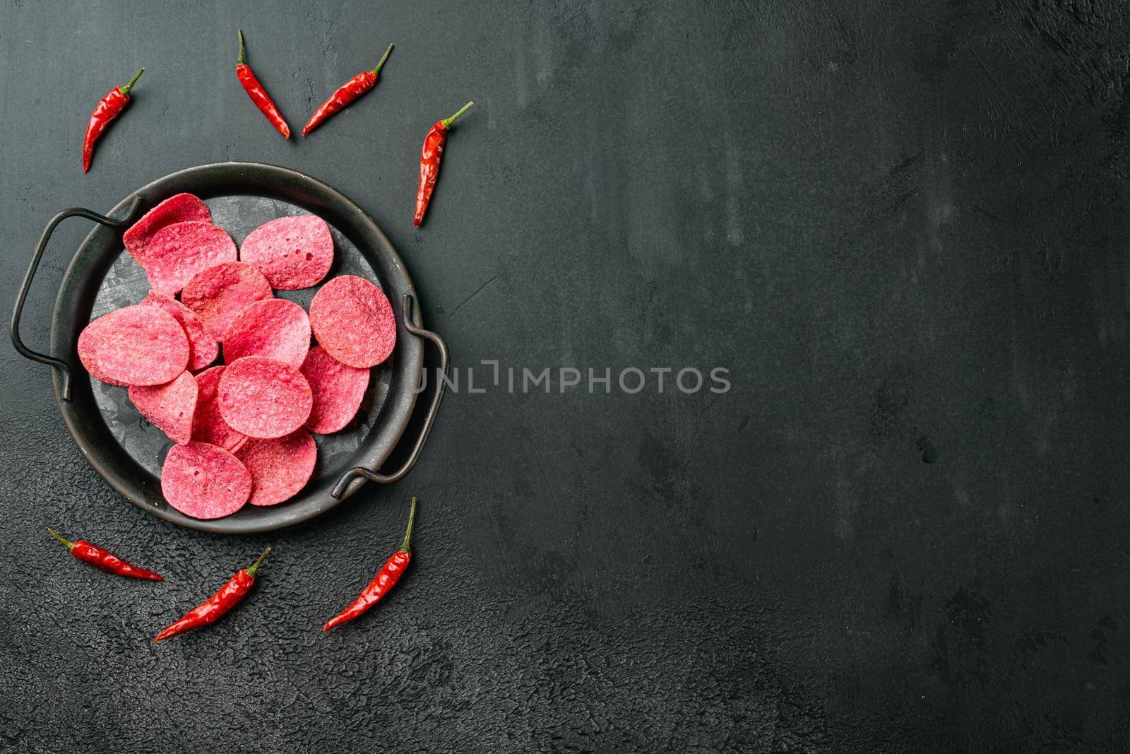 Hickory BBQ Flavored red Potato Chips, on black dark stone table background, top view flat lay, with copy space for text