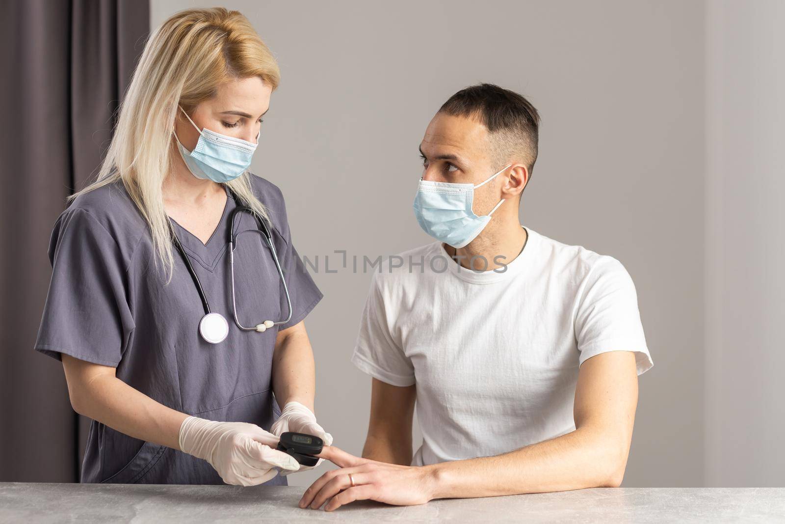 Close-up image of doctor measuring oxygen saturation of patient with pulse oximeter device