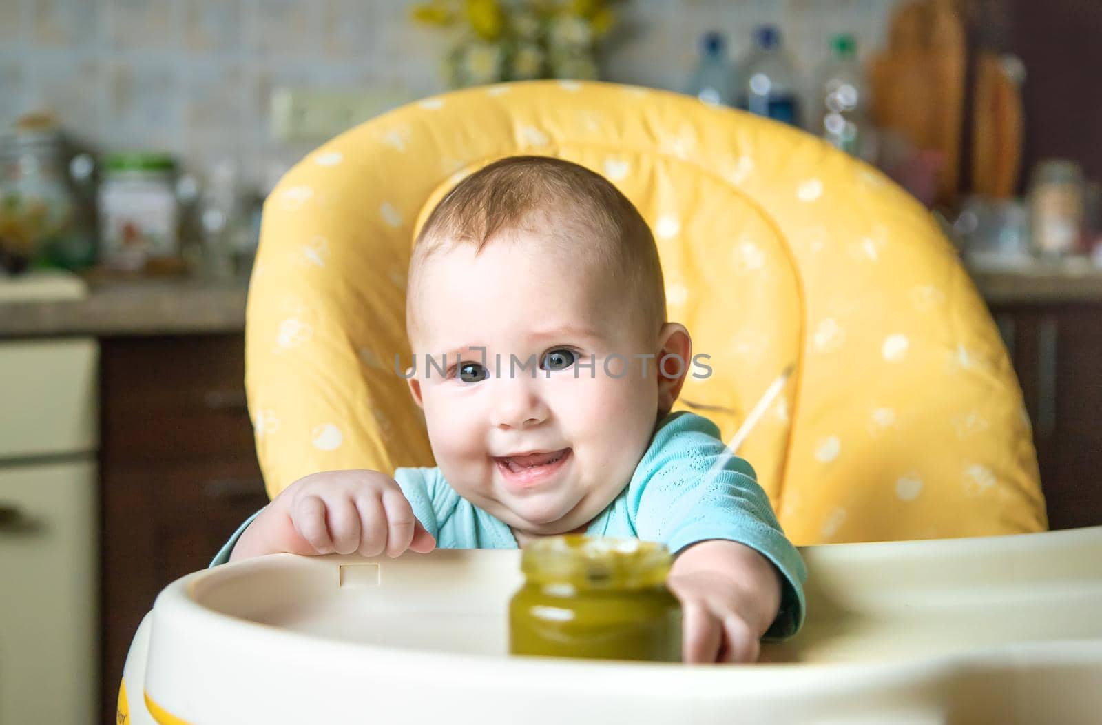 Little baby is eating broccoli vegetable puree. Selective focus. people.