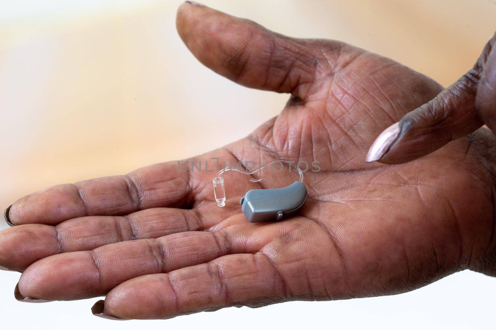Hearing aid in close-up in the hollow of the hand