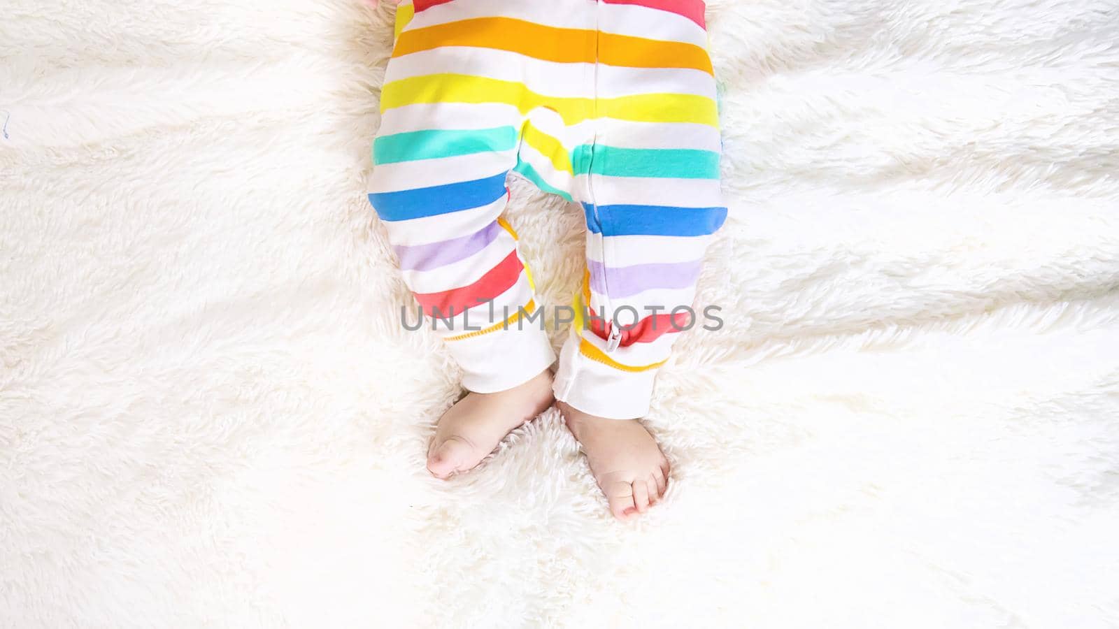 baby feet on a white background bed. Selective focus. Child.