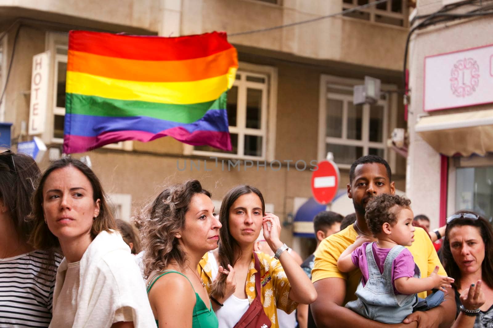 Santa Pola, Alicante, Spain- July 2, 2022: Spanish People attending Gay Pride Parade with rainbow flags, banners and colorful costumes