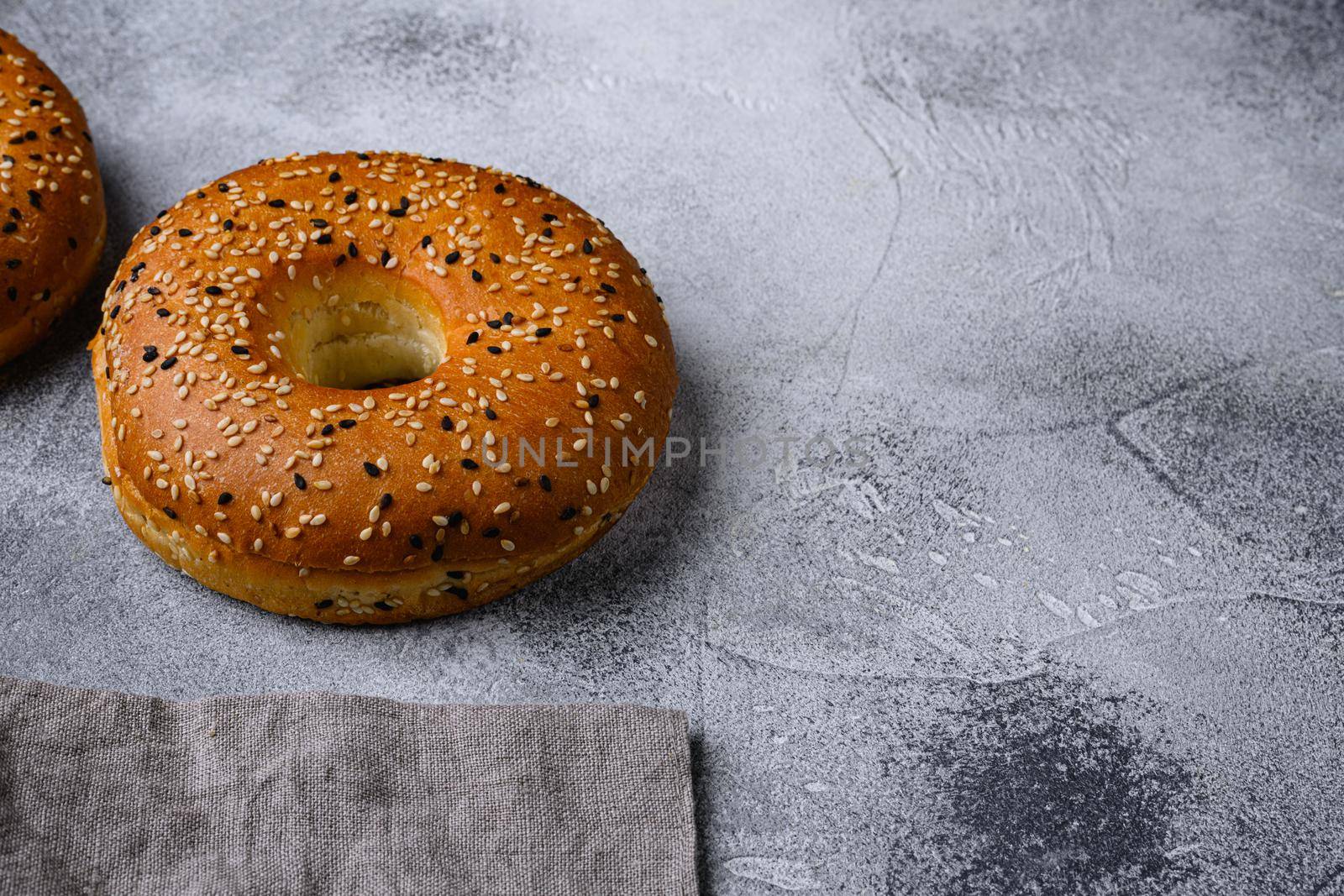 Fresh Sesame Bagel, on gray stone table background, with copy space for text