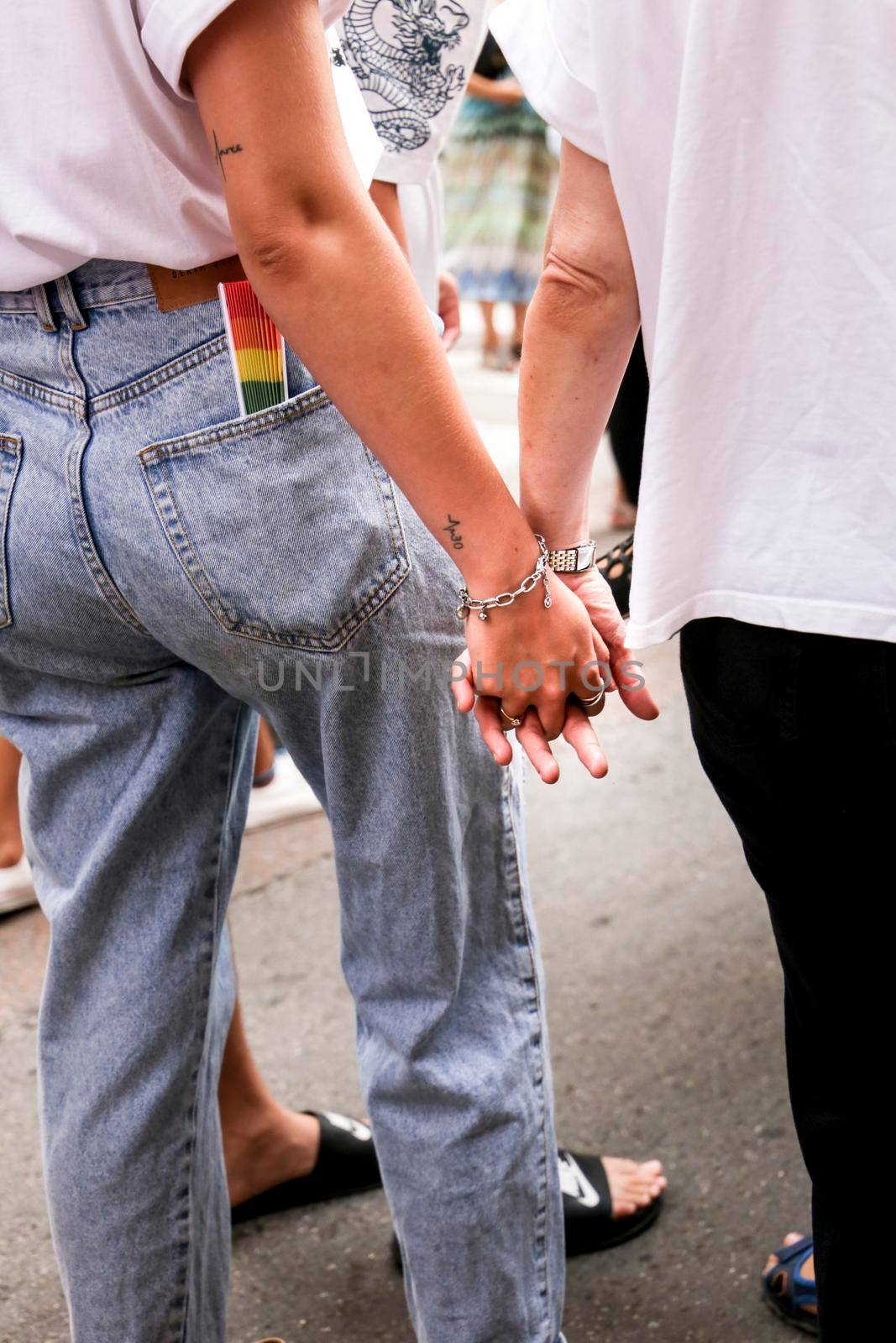 Two lesbian girls holding hands at the Gay Pride Festival in Santa Pola town by soniabonet