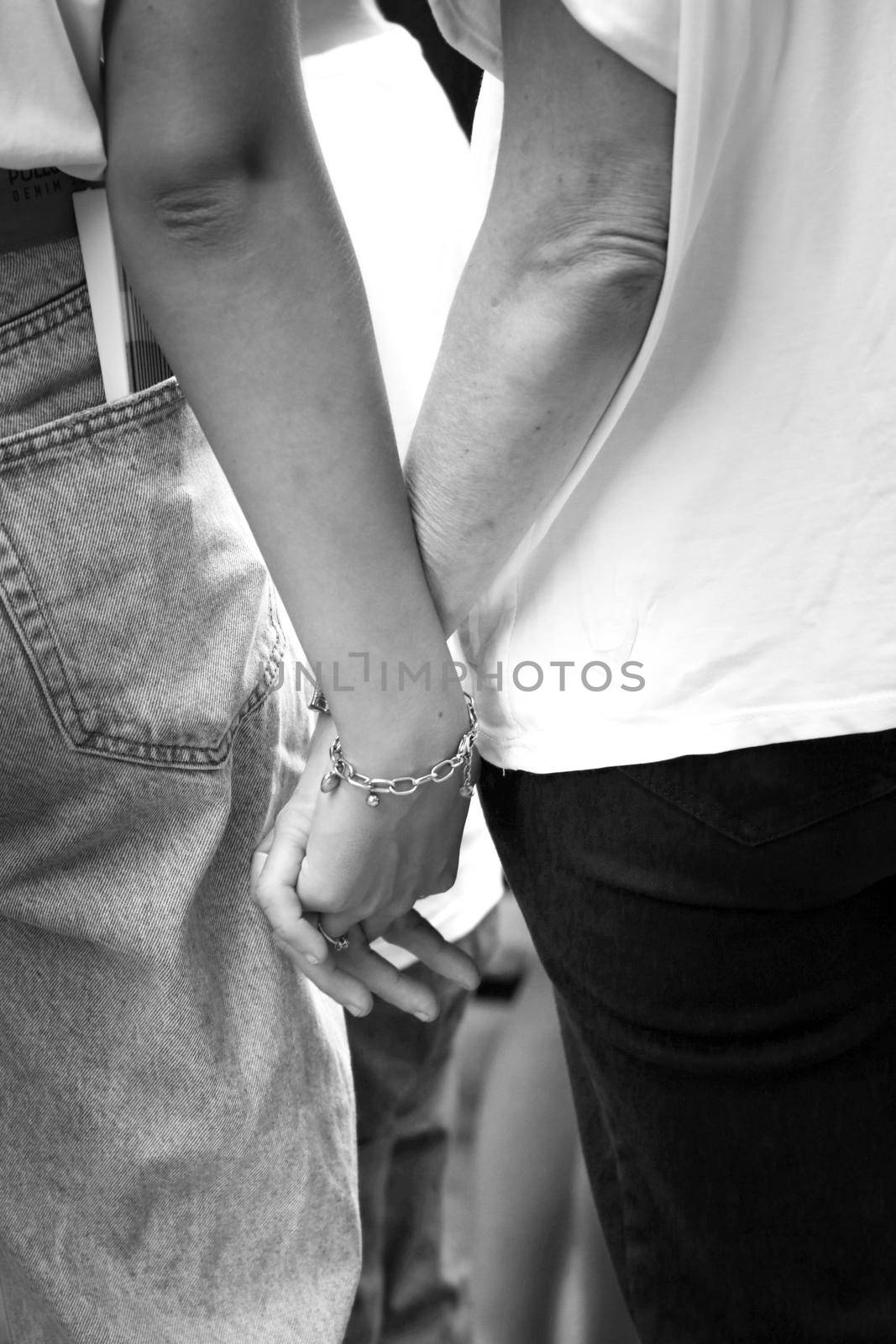 Two lesbian girls holding hands at the Gay Pride Festival in Santa Pola town by soniabonet
