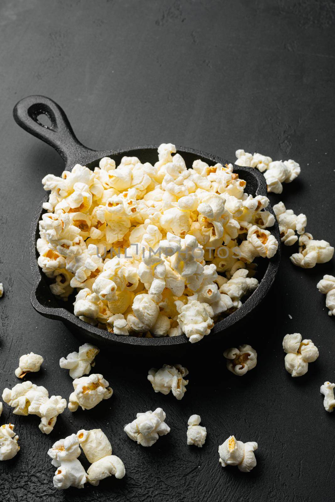 Salted popcorn, on black dark stone table background