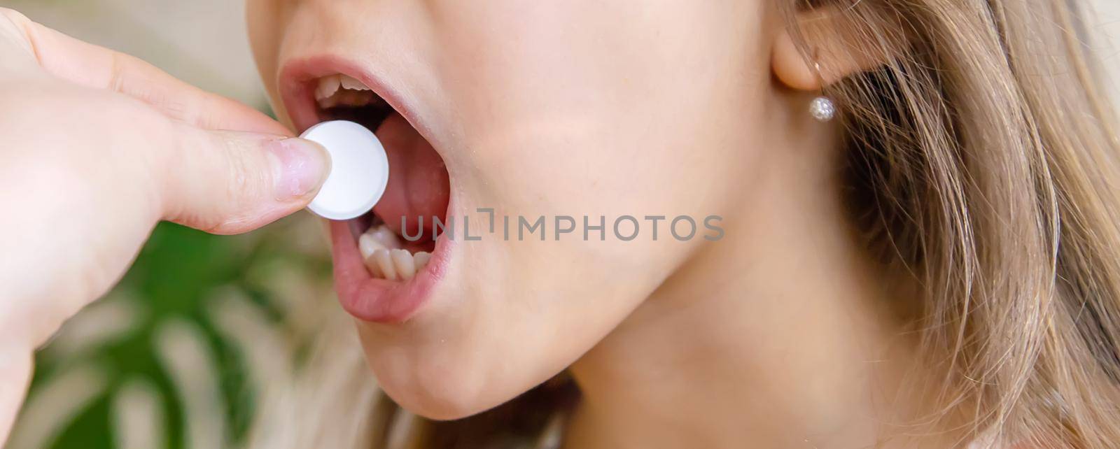 mother giving vitamin c pill to her child. dietary supplements for kids. Selective focus. by yanadjana