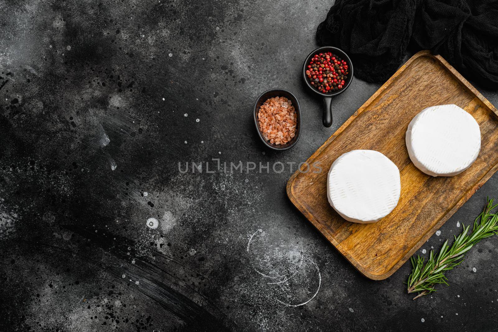 Fresh Brie cheese, on black dark stone table background, top view flat lay, with copy space for text