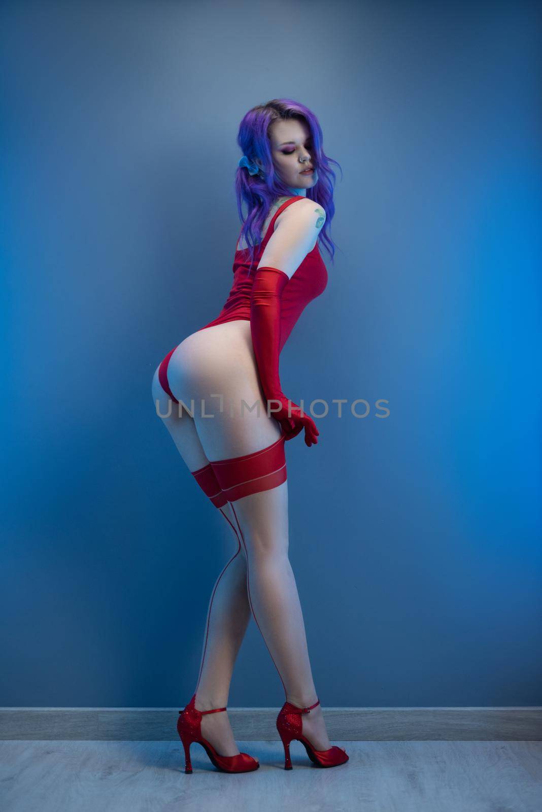 sexy girl in red bodysuit stockings and red gloves poses erotically against the background by Rotozey