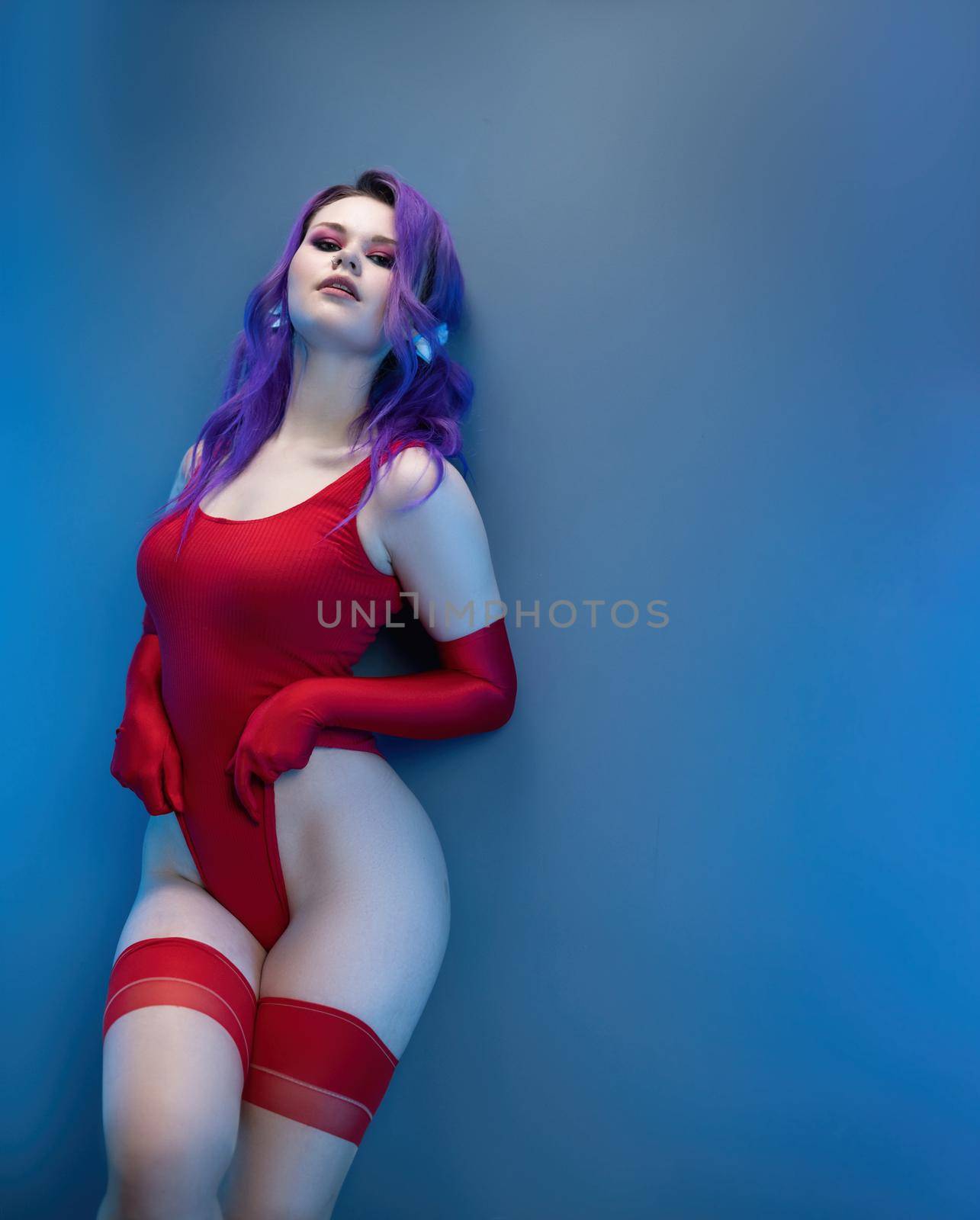 sexy girl in red bodysuit stockings and red gloves poses erotically against the background by Rotozey